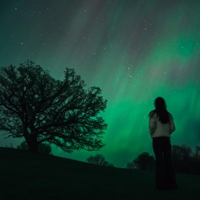 Students watching green Northern Lights at the Hill of Three Oaks