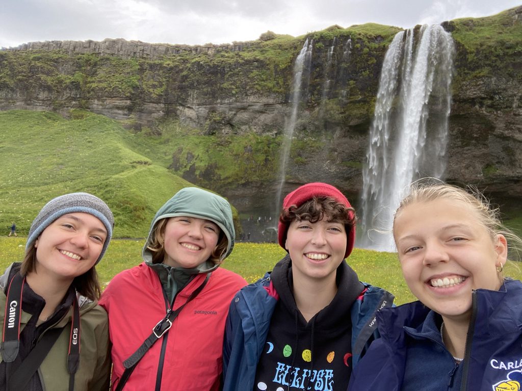 Four students in front of a waterfall