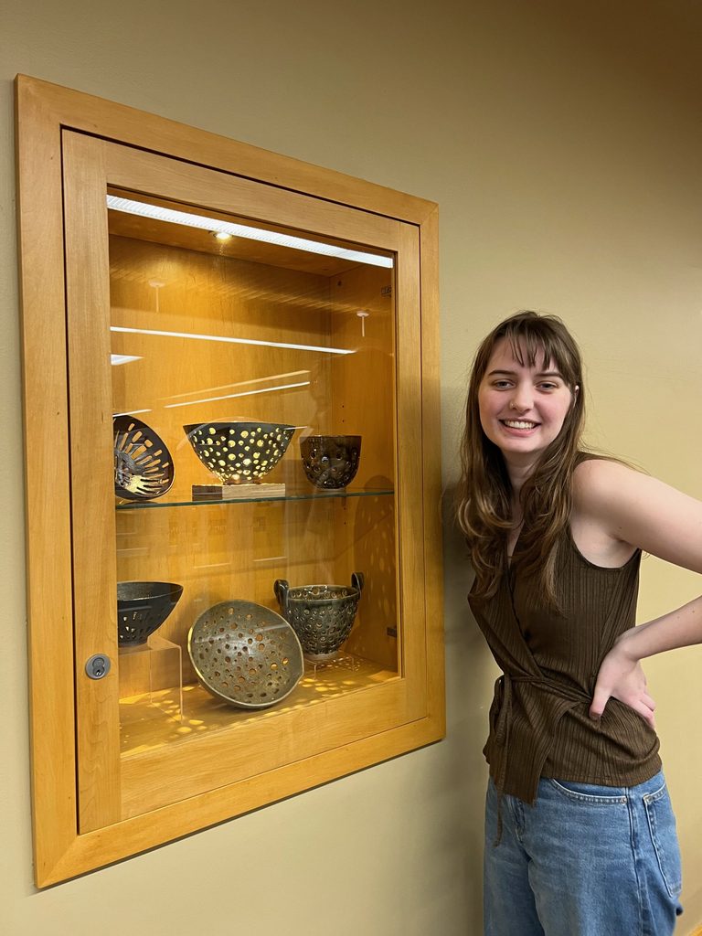 Sequoia Wyckoff '25 with a display of her work in the library