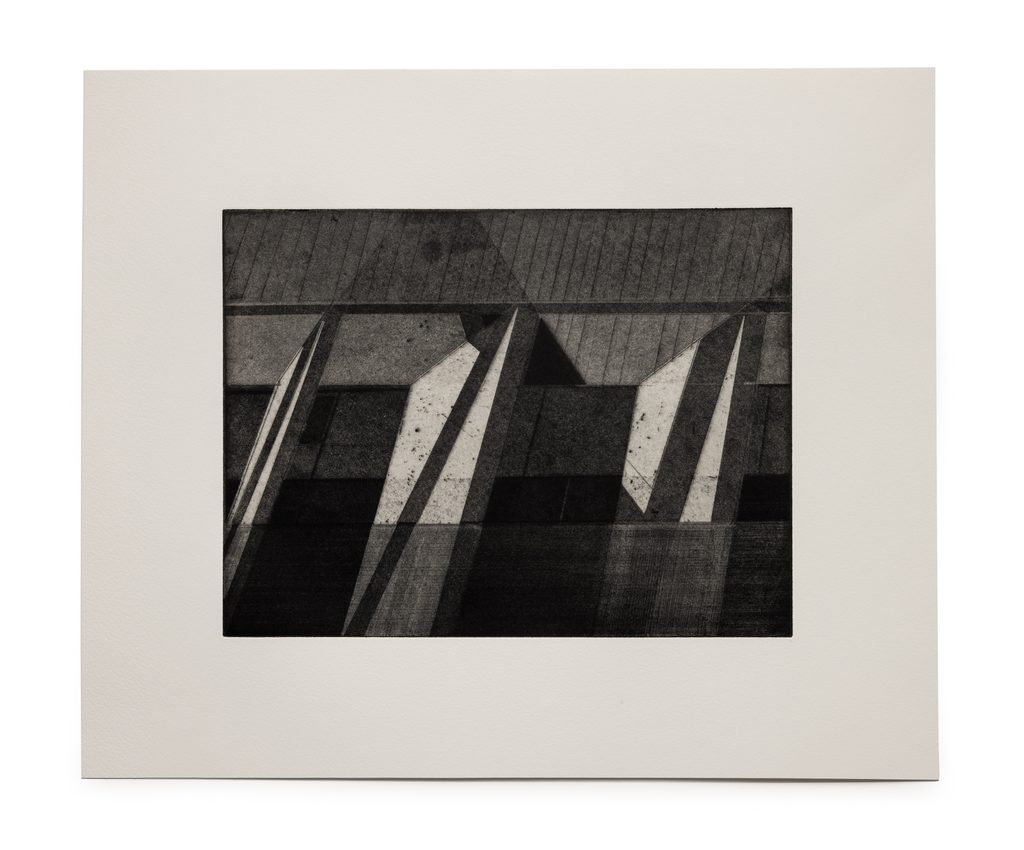 A grayscale printed image of angled planes evoking architectural shapes in shades of gray