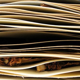 A photo taken from the side of a stack of paper with natural materials layered in between.