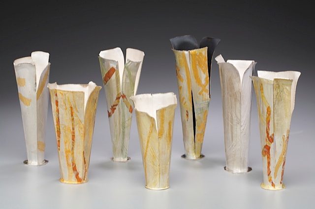 An image of seven elegant vessels made primarily of silver