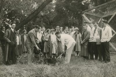 A black and white historical photo of people ceremoniously planting a tree in the arb in 1927
