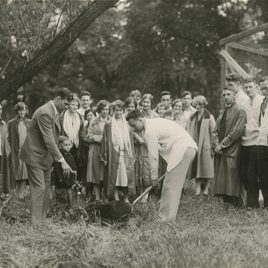 A black and white historical photo of people ceremoniously planting a tree in the arb in 1927