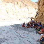 Shaded students listening to lesson while in small canyon