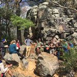 Students gathered on rocks, listening to instructor