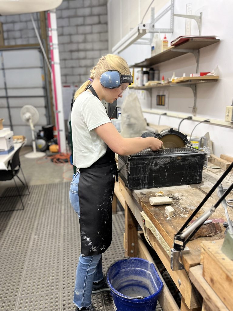 A student cuts rocks using a rock saw.