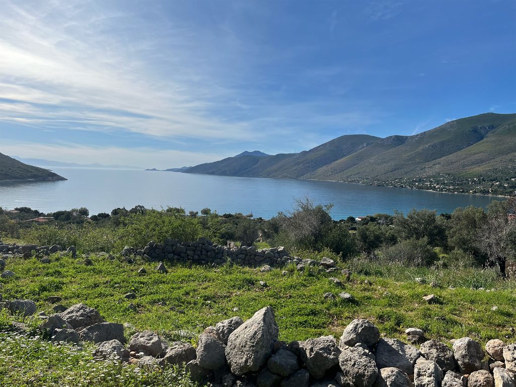 view from the fortress overlooking mountains, green grass, and water