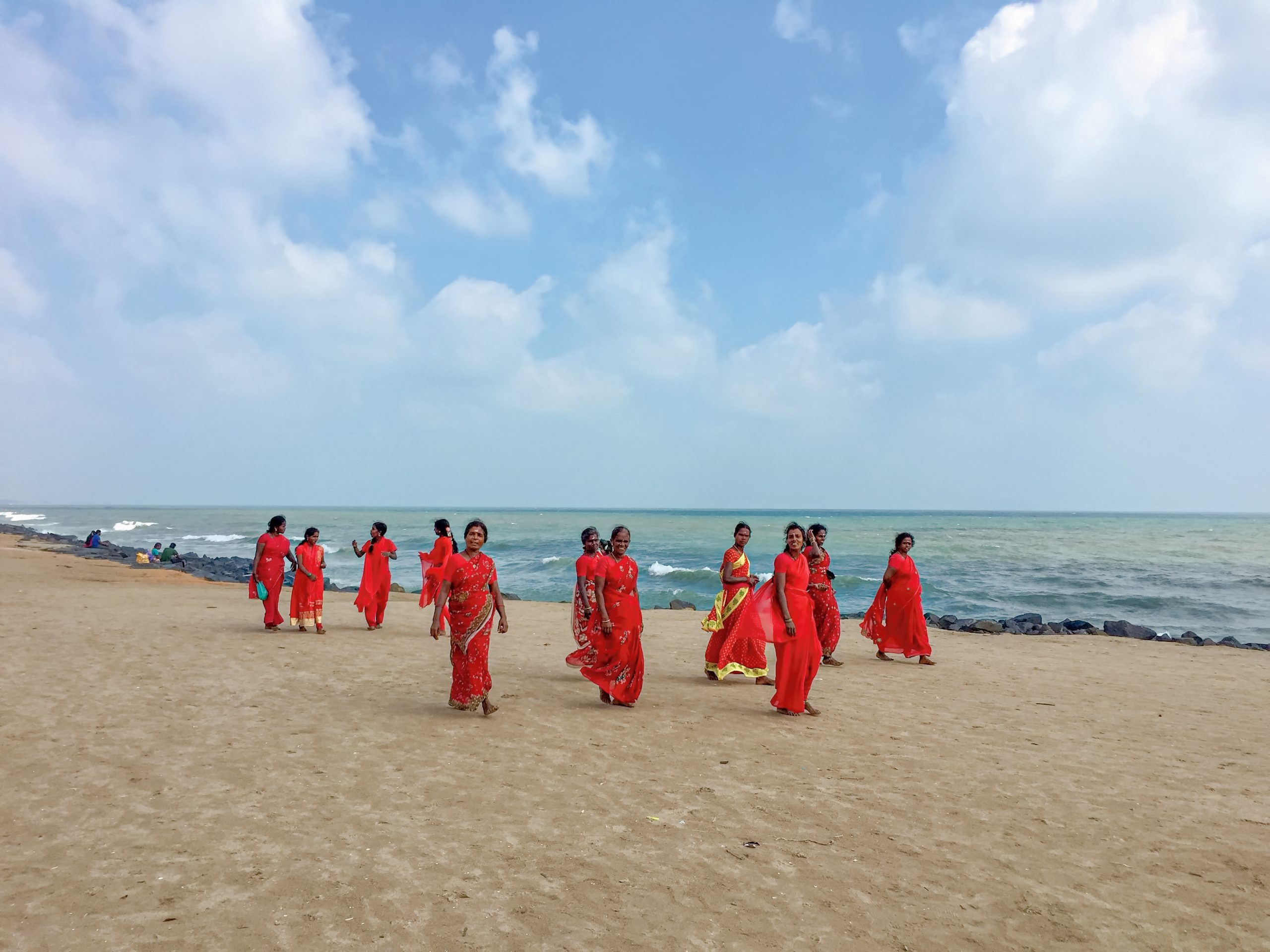 Women in red robes on a beach