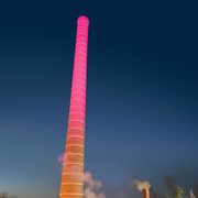 Carleton's smokestack lit up in celebration of the End of Steam on campus