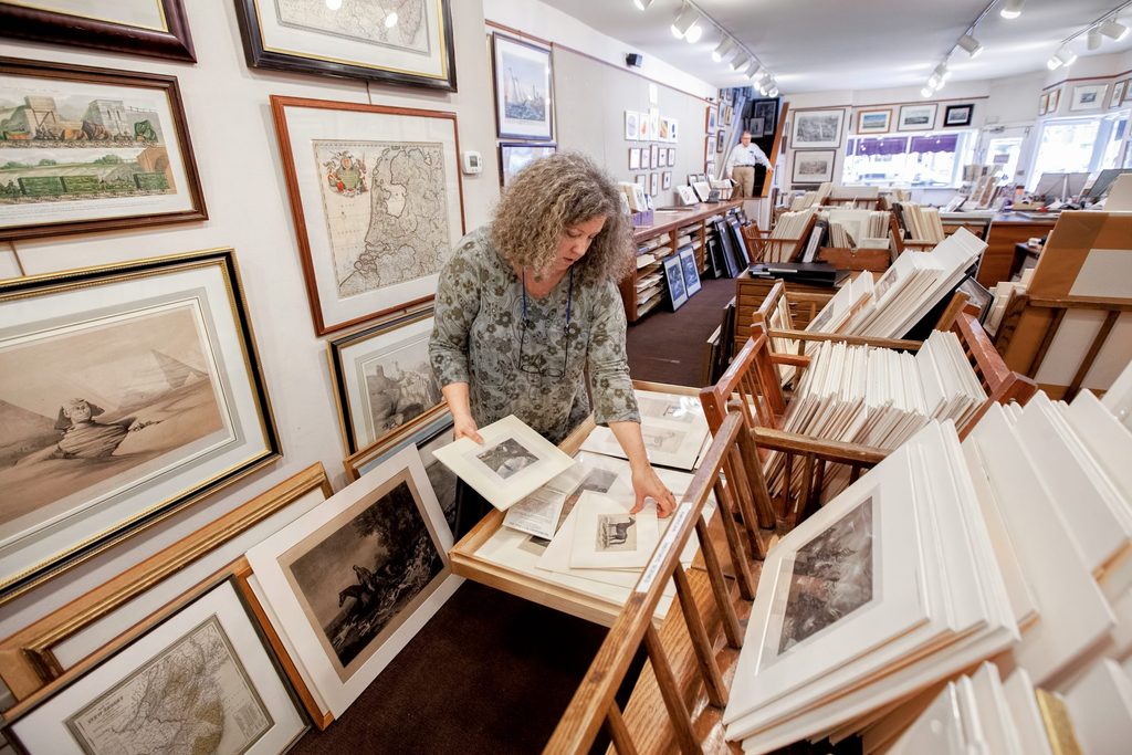 Lisa Jane Toczek searches through a pile of matted prints