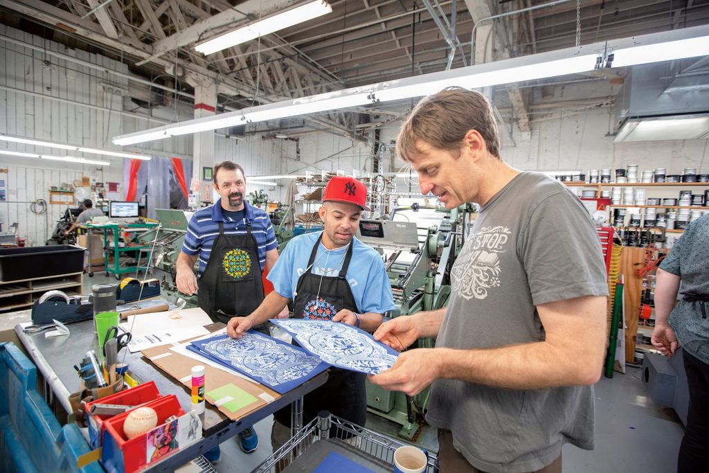 Boxcar Press owner Harold Kyle ’98 reviews a print sample with press operator Will Cartagena.