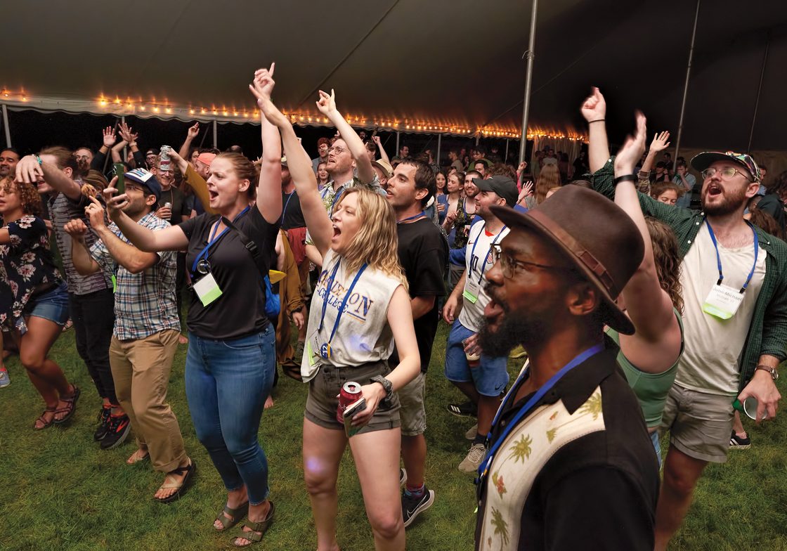 A crowd dances to live music at a reunion concert