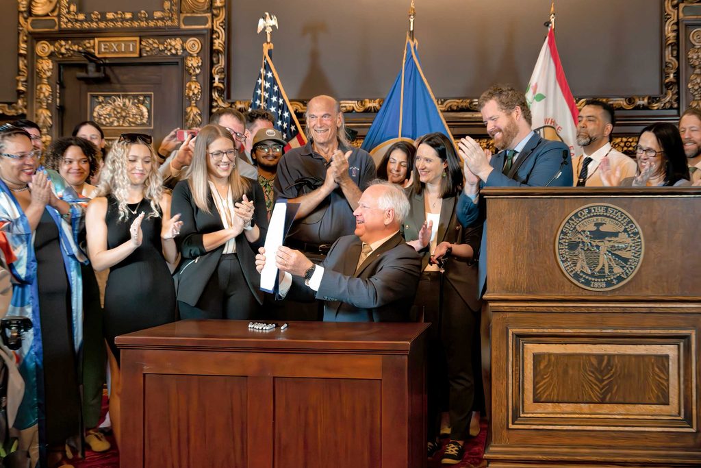 Governor Tim Walz with state legislators and former governor Jesse Ventura after signing the bill making adult-use marijuana legal in Minnesota