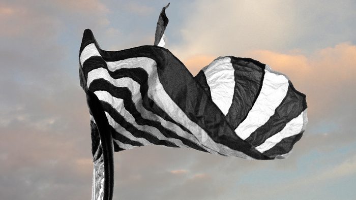 Photo by Amadeo Lasansky of a twisted American flag against an evening sky