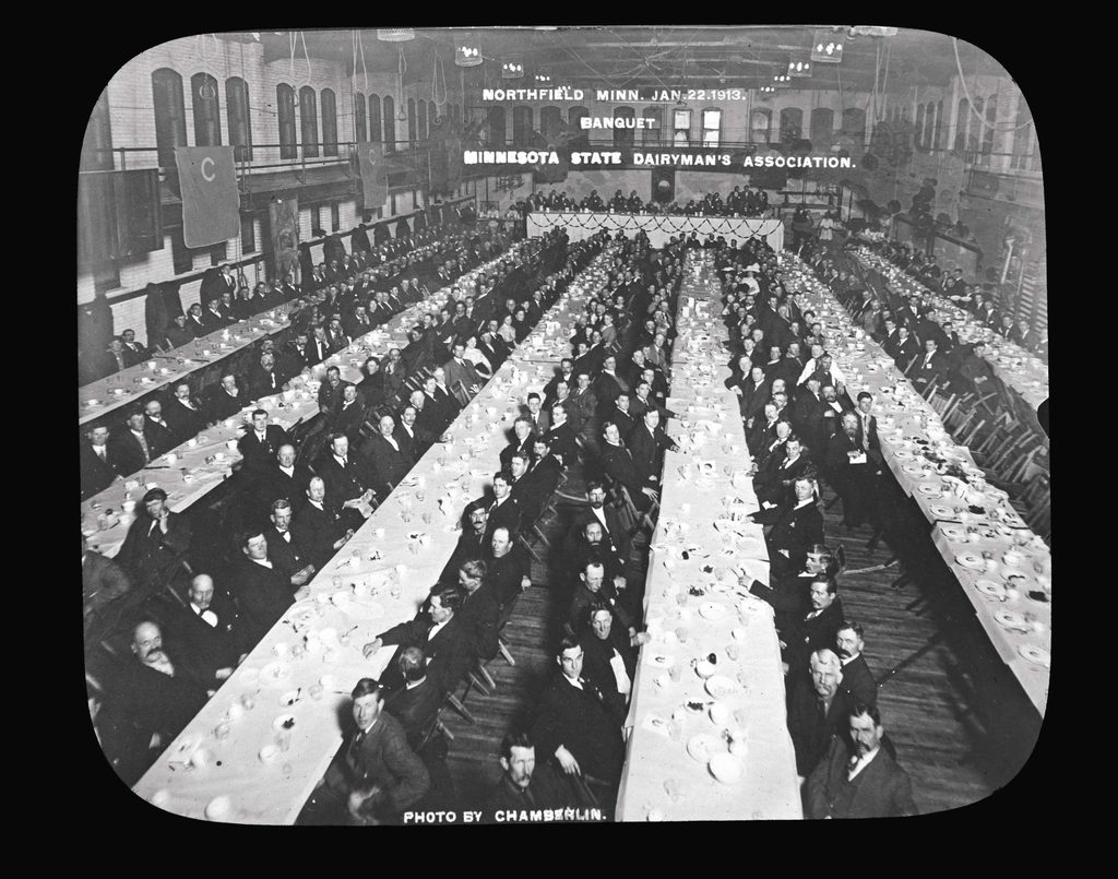 vintage photo of rows of dining tables with people eating
