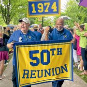 alumni carry a 50th Reunion banner at the parade of classes