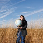 Zainab Waheed holding a globe standing in the arb