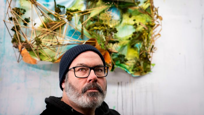 Artist Gregory Euclide in front of one of his sculptural collages