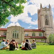 students seated on the grass outside skinner memorial chapel