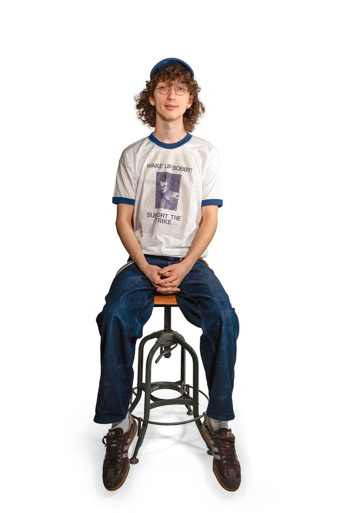 student seated wearing food workers strike tshirt