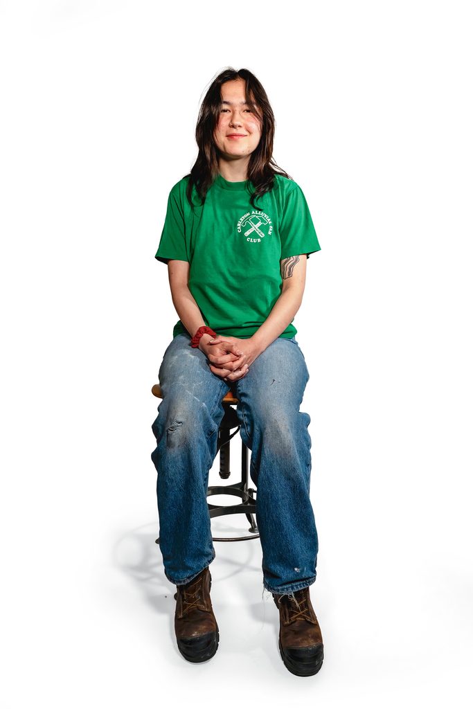 student seated wearing green geology department tshirt