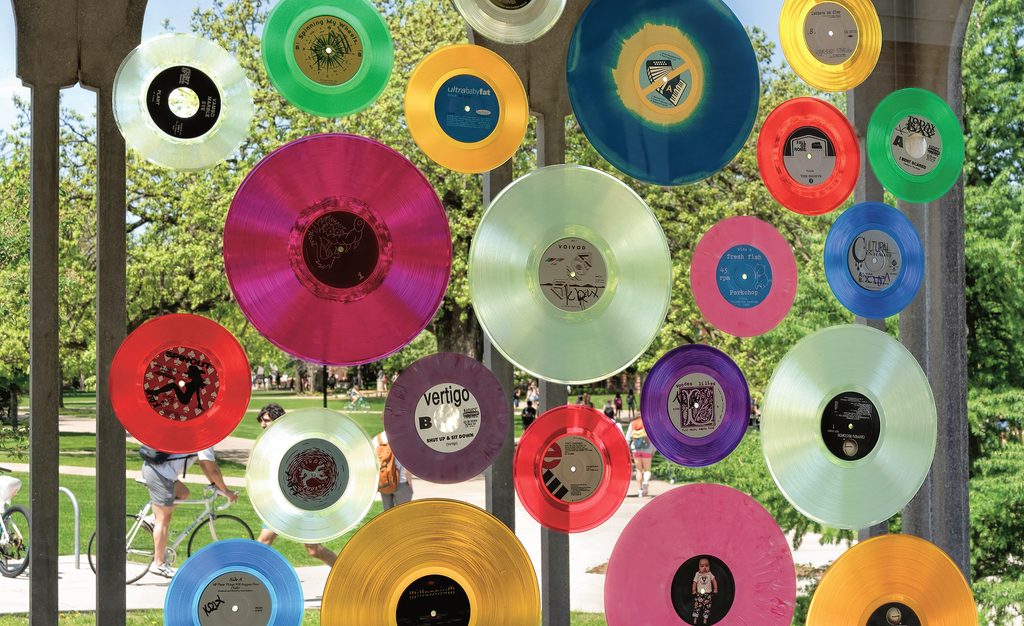 colored vinyl records hang in a sunny window