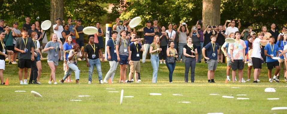 students throwing frisbees on the bald spot