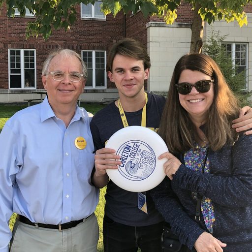 Parents and son hold a Carleton College Frisbee