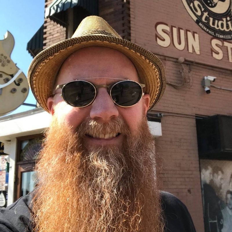 A smiling bearded man in sunglasses in front of Sun Studio in Memphis, Tennessee