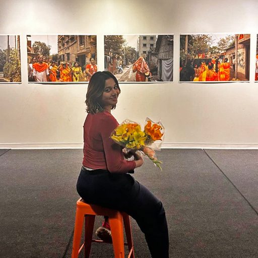 Annanya Sinha '25 with her photos in an exhibition in the Hamlin Creative Space