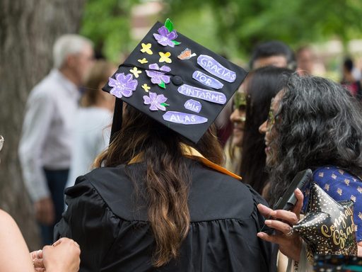A student at commencement with a mortar board reading: gracias por pintarme mis alas