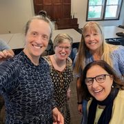 A group of four professors stand together posing for a photo.