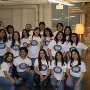 A group of students stand in a group celebrating a Quinceanera event.