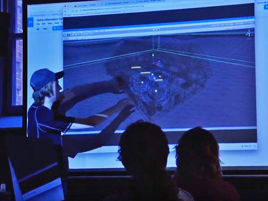 A student interacts with a projected 3d model on a screen