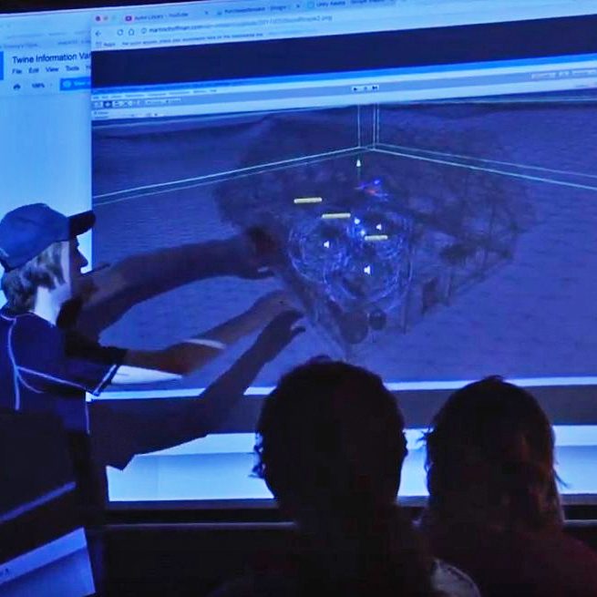 A student interacts with a projected 3d model on a screen