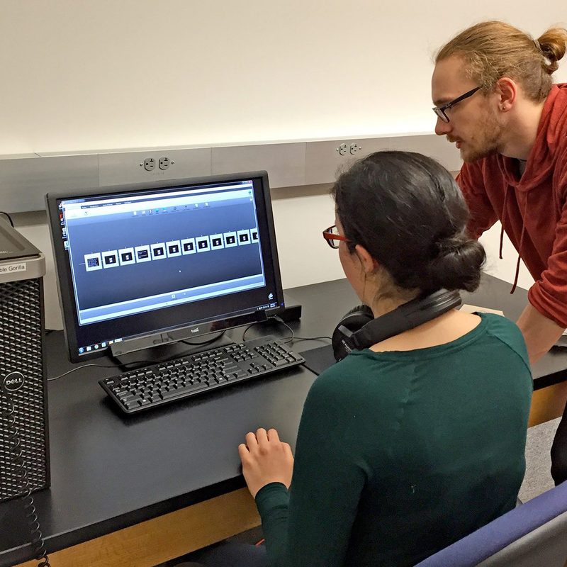 Two students look at a computer monitor in the perception lab.