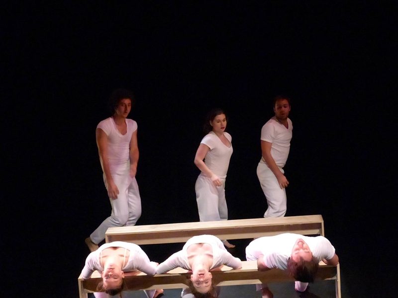 Dancers wearing white and using benches as props