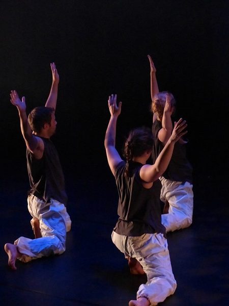 Dancers kneeling with their arms up