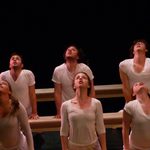 Dancers wearing white and looking up