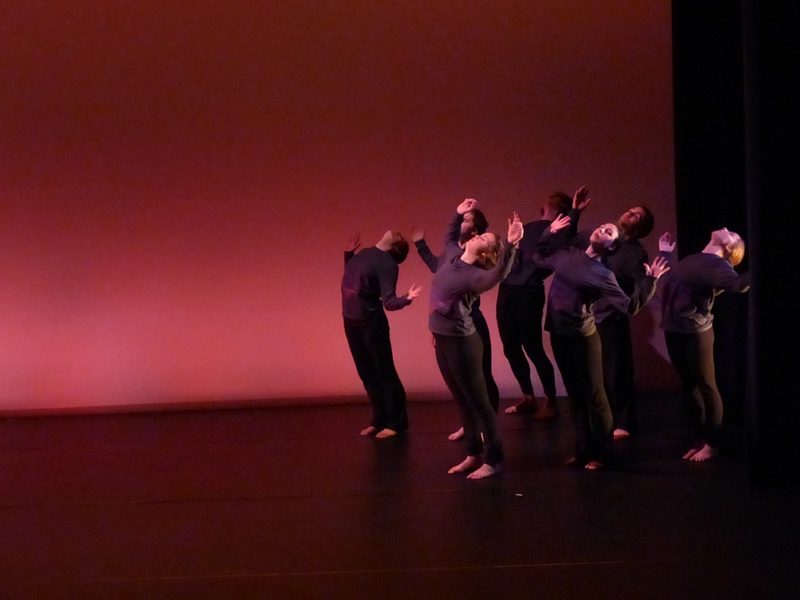 Dancers standing together on stage and leaning backwards