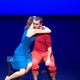 A dancer in blue hugging a dancer in red