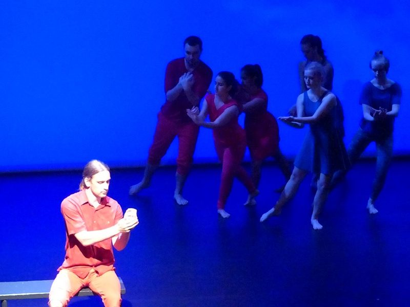 A dancer at the front of the stage and other dancers in the background
