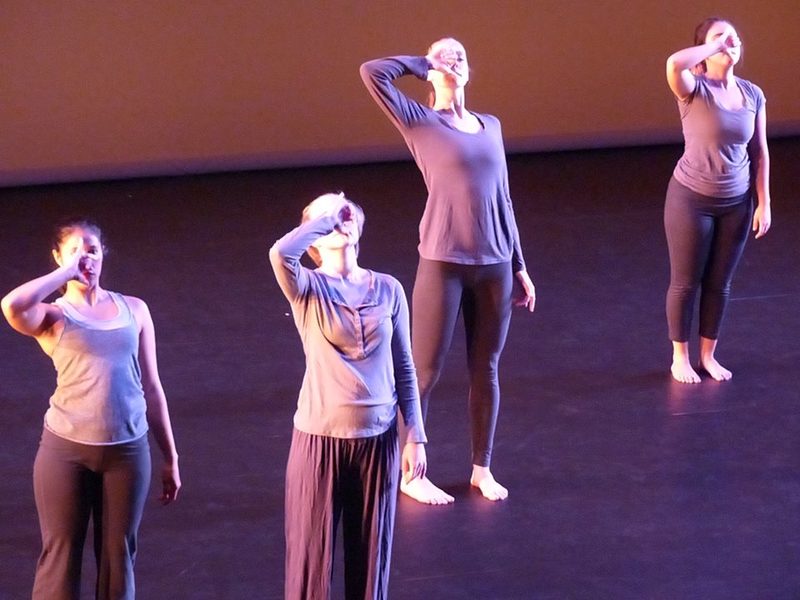 Dancers standing and holding their hands to their mouth