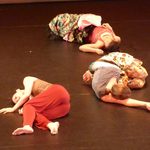 Three dancers laying on the floor