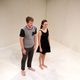 Man and a woman standing barefoot in a white room