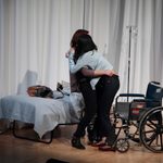 A woman embracing and helping a woman out of her wheelchair