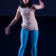 A dancer in blue pants standing and moving her arms