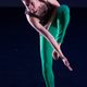 A dancer in green pants bending over and standing on one leg