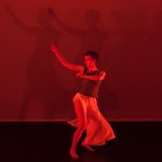 A dancer in motion under a red light